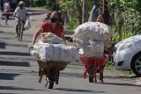 Sejumlah warga membawa karung berisi sampah plastik untuk ditukarkan dengan beras dalam aksi sosial di Bank Sampah Luwu Mas, Desa Sayan, Gianyar, Bali, Selasa (9/6/2020). Penukaran sampah plastik dengan beras tersebut untuk membantu meringankan perekonomian warga yang terdampak COVID-19 sekaligus gerakan kebersihan lingkungan dari sampah plastik. ANTARA FOTO/Nyoman Hendra Wibowo/nym.