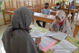 Seorang murid Sekolah Ibtidaiyah Negeri (MIN) mengikuti tes kemampuan membaca Alquran sebelum dilanjutkan ujian berbasis komputer saat masuk Sekolah Madrasah Tsanawiyah Negeri (MTsN) di Banda Aceh, Aceh, Rabu (10/6/2020). Ujian masuk sekolah penerimaan murid baru tahun ajaran 2020/2021 di tingkat Madrasyah daerah itu menerapkan protokol kesehatan dengan mewajibkan murid menggunakan masker, menjaga jarak dan pemeriksaan suhu badan dalam upaya mencegah penyebaran COVID-19. Antara Aceh/Ampelsa.