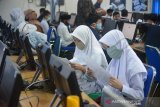 Sejumlah murid Sekolah Ibtidaiyah Negeri (MIN) mengikuti ujian berbasis komputer dan dilanjutkan tes kemampuan membaca Alquran saat masuk Sekolah Madrasah Tsanawiyah Negeri (MTsN)  di Banda Aceh, Aceh, Rabu (10/6/2020). Ujian masuk sekolah penerimaan murid baru tahun ajaran 2020/2021 di tingkat Madrasyah daerah itu menerapkan protokol kesehatan dengan mewajibkan murid menggunakan masker dan menjaga jarak dan pemeriksaan suhu badan dalam upaya mencegah penyebaran COVID-19. Antara Aceh/Ampelsa.
