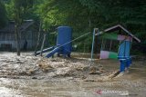 Seorang warga melihat arus deras banjir di Desa Alale, Kabupaten Bone Bolango, Gorontalo, Kamis (11/6/2020). Hujan yang melanda daerah itu sejak hari Rabu (11/6) malam, menyebabkan meluapnya sungai Bone dan bendungan jebol sehingga merendam ratusan rumah warga. (ANTARA FOTO/Adiwinata Solihin)