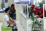 Petugas melayani warga yang memanfaatkan layanan di Mal Pelayanan publik Banyuwangi, Jawa Timur, Kamis (11/6/2020). Pembukaan kembali layanan publik setelah ditutup akibat terdampak pandemi COVID-19 itu, sebagai persiapan tatanan normal baru. Saat ini baru ada 8 instansi pemerintah daerah dengan 110 jenis layanan yang sudah bisa diakses warga dan akan dibuka secara bertahap dari semula 213 jenis layanan. Antara Jatim/Budi Candra Setya/zk