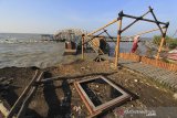 Warga melihat puing bangunan objek wisata yang rusak diterjang ombak di Pantai Rembat, Juntinyuat, Indramayu, Jawa Barat, Jumat (12/6/2020). Berbagai sarana wisata dan bangunan lapak pedagang di objek wisata pantai tersebut rusak akibat gelombang pasang yang terjadi sejak dua pekan terakhir. ANTARA JABAR/Dedhez Anggara/agr