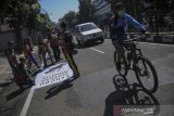 Sejumlah anggota komunitas Gowes Baraya Bandung membuat jalur bagi pesepeda di Jalan Merdeka, Bandung, Jawa Barat, Jumat (12/6/2020). Pemerintah Kota Bandung bekerjasama dengan berbagai komunitas pesepeda untuk membuat jalur sepeda di jalan utama Kota Bandung seiring dengan berkembangnya tren bersepeda saat pandemi COVID-19. ANTARA JABAR/Raisan Al Farisi/agr