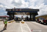 Pekerja melintas di depan gerbang tol Indrapuri yang telah siap dioperasionalkan, Aceh Besar, Kamis (11/6/2020). Pembangunan jalan tol seksi IV Blangbintang-Indrapuri sepanjang 14 Km yang merupakan bagian dari tol Banda Aceh - Sigli sepanjang 74 kiometer telah rampung hingga 90 persen lebih dan dapat dioperasikan pada Juli 2020. Antara Aceh/Irwansyah Putra.