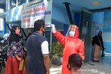 Petugas kesehatan memeriksan suhu tubuh warga saat berobat di Kuta Alam, Banda Aceh, Aceh, Senin (15/6/2020). Memasuki tatanan baru, pemerintah setempat meningkat protokol kesehatan dalam upaya mencegah penyebaran COVID-19 Antara Aceh/Ampelsa.