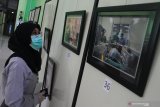 Pengunjung melihat foto bertema pelayanan kesehatan karya dokter dan tenaga medis yang dipajang dalam Pameran Fotografi di Aula Majapahit, Rumah Sakit Syaiful Anwar, Malang, Jawa Timur, Senin (15/6/2020). Pameran fotografi yang menampilkan 84 karya foto dan berlangsung selama empat hari tersebut diadakan sebagai bentuk penghargaan terhadap kerja keras para dokter serta tenaga medis dalam merawat pasien di saat pandemi COVID-19. Antara Jatim/Ari Bowo Sucipto/zk.