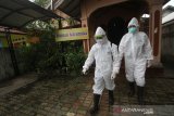 Relawan menggunakan Alat Pelindung Diri (APD) menyemprotkan disinfektan di halaman rumah karantina swadaya masyarakat di Kampung Tangguh Banua di Batu Benawa Kelurahan Teluk Dalam Banjarmasin, Kalimantan Selatan, Rabu (17/6/2020). Warga di daerah tersebut menginisiasi kampung tangguh dengan menpersiapkan semua protokol kesehatan seperti membentuk petugas tanggap COVID-19 dan posko layanan kesehatan hingga rumah karantina khusus sebagai upaya memutus mata rantai penyebaran COVID-19. Foto Antaranews Kalsel/Bayu Pratama S.