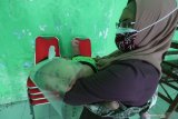 Seorang ibu bersama anaknya menunggu giliran mendapatkan imunisasi di kantor Kelurahan Pesantren, Kota Kediri, Jawa Timur, Rabu (17/6/2020). Memasuki era transisi normal baru pemberian imunisasi untuk balita di wilayah tersebut diberlakukan penjatwalan berdasarkan domisili per kelurahan guna menghindari kerumunan pemicu penyebaran COVID-19. Antara Jatim/Prasetia Fauzani/zk.