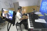 Pengajar kelas kursus musik Hadi Santosa melakukan siaran langsung (live streaming) saat bermain pembelajaran piano untuk siswanya di Fahrezi music Studio di Indramayu, Jawa Barat, Rabu (17/6/2020). Di masa pandemi saat ini, pengelola studio tersebut menggelar kelas musik secara daring dan mengikuti anjuran pemerintah agar mengurangi interaksi untuk mencegah penyebaran COVID-19. ANTARA JABAR/Dedhez Anggara/agr