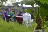 Petugas medis bersama warga mengangkat peti berisi jenazah pasien positif COVID-19 saat pemakaman di salah satu lokasi dalam wilayah Kabupaten Aceh Besar, Aceh, Rabu (17/6/2020). Gugus Tugas Percepatan Penanganan COVID-19 Aceh menyatakan hingga saat ini kasus positif COVID-19 sebanyak 37 orang, 15 orang di antaranya dalam perawatan, 20 orang sembuh dan dan dua orang meninggal. Antara Aceh/Ampelsa.