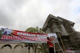 Petugas Dinas Pariwisata memasang spanduk berisi seruan kepada peziarah dan pengunjung di depan gerbang masuk kawasan  Makam Presiden Soekarno di Blitar, Jawa Timur, Jumat (19/6/2020). Memasuki masa normal baru, Pemkot Blitar berencana membuka kembali kawasan Makam Presiden Soekarno pada Sabtu (20/6/2020) dan mewajibkan para pengunjung maupun peziarah untuk tetap mematuhi protokol kesehatan, guna mencegah penularan virus COVID-19. Antara Jatim/Irfan Anshori/zk.