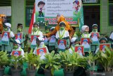 Guru memandu siswa berjalan mengambil posisi berdiri dengan jarak tertentu pada sesi foto bersama di akhir acara purnawiyata di TK Al Khodijah, Tiudan, Tulungagung, Jawa Timur, Sabtu (20/6/2020). Memasuki era kenormalan baru sekolah ini menerapkan protokol kesehatan ketat saat melaksanakan seremoni wisuda 60 siswa TK dan KB (kelompok belajar/pendidikan usia dini) setempat dengan tujuan untuk mencegah penularan virus COVID-19. Antara Jatim/Destyan Sujarwoko/zk