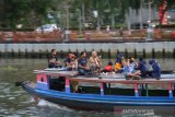 Sejumlah warga menaiki kelotok (perahu bermesin) tanpa jaga jarak saat susur sungai Martapura di kawasan wisata Menara Pandang Siring Sungai Martapura Banjarmasin, Kalimantan Selatan, Minggu (21/6/2020). Meski Pemerintah Kota Banjarmasin belum membuka wisata Menara Pandang namun warga mulai ramai memadati kawasan salah satu landmark di Kalimantan Selatan itu. Foto Antaranews Kalsel/Bayu Pratama S.