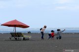 Pengunjung bermain di Pantai Boom, Banyuwangi, Jawa Timur, Minggu (21/6/2020). Setelah mendapatkan sertifikat normal baru dari  dinas kesehatan setempat, wisata Pantai Boom mulai membuka simulasi kunjungan wisatawan. Antara Jatim/Budi Candra Setya/zk.