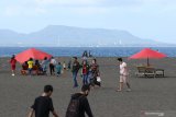 Pengunjung bermain di Pantai Boom, Banyuwangi, Jawa Timur, Minggu (21/6/2020). Setelah mendapatkan sertifikat normal baru dari  dinas kesehatan setempat, wisata Pantai Boom mulai membuka simulasi kunjungan wisatawan. Antara Jatim/Budi Candra Setya/zk.