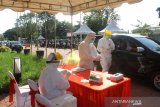 Petugas kesehatan mengambil sampel lendir warga saat tes usap (swab test) drive-thru di Jalan Jendral Sudirman Banjarmasin, Kalimantan Selatan, Rabu (24/6/2020). Dalam rangka HUT Bhayangkara, Polda Kalsel bersama Dinas Kesehatan Kota Banjarmasin menggelar swab test drive-thru dengan target 500 peserta guna memutus rantai penularan COVID-19 di Kalimantan Selatan. Foto Antaranews Kalsel/Bayu Pratama S.