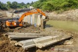 Petugas mengoperasikan alat berat saat membongkar dinding turap (sheet pile) yang terpasang di tengah bantaran sungai Cibeet di Desa Cipayung, Cikarang Timur, Kabuaten Bekasi, Jawa Barat, Kamis (25/6/2020). Kementerian Agraria dan Tata Ruang / Badan Pertanahan Nasional (ATR/BPN) membongkar dinding turap di tengah sungai Cibeet yang dipasang oleh oknum pengelola objek wisata yang tidak memiliki izin pemanfaatan ruang yang berpotensi merusak sempadan dan kualitas air sungai. ANTARA JABAR/M Ibnu Chazar/agr
