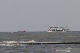 Sejumlah nelayan berusaha mengevakuasi kapal yang terbalik untuk di perairan Karangsong, Indramayu, Jawa Barat, Jumat (26/6/2020). Kapal nelayan pencari cumi-cumi tersebut terbalik akibat diterjang ombak besar yang terjadi beberapa waktu lalu dan tidak ada korban jiwa dalam peristiwa tersebut. ANTARA JABAR/Dedhez Anggara/agr