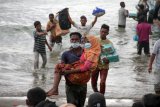 Warga melakukan evakuasi paksa pengungsi etnis Rohingya dari kapal di pesisir pantai Lancok, Kecamatan Syantalira Bayu, Aceh Utara, Aceh, Kamis (25/6/2020). Warga terpaksa melakukan evakuasi paksa 94 orang pengungsi etnis Rohingya ke darat yang terdiri dari 15 orang laki-laki, 49 orang perempuan dan 30 orang anak-anak tanpa seizin pihak terkait, karena warga menyatakan tidak tahan melihat kondisi pengungsi Rohingya yang memprihatikan di dalam kapal sekitar 1 mil dari bibir pantai dalam kondisi. terutama anak-anak dan wanita dalam kondisi lemas akibat dehidrasi dan kelaparan. ANTARA FOTO/Rahmad/aww.