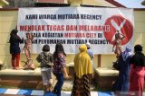 Warga menandatangai spanduk sebagai bentok penolakan yang terpasang di perumahan Pondok Mutiara, Sidoarjo, Jawa Timur, Sabtu (27/6/2020). Mereka menolak jalan perumahan mereka dijadikan akses keluar masuk ke Mutiara City yang saat ini dalam proses pembangunan akan mengganggu kenyamanan warga dikawasan tersebut. Antara Jatim/Umarul Faruq/zk