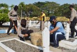 Anggota Polri bersama prajurit TNI membersihkan kawasan Taman Makam Pahlawan (TMP) Madiun, Jawa Timur, Sabtu (27/6/2020). Dalam rangka menyambut HUT ke-74 Bhayangkara Polres Madiun Kota bersama institusi TNI dan Pemkot Madiun melakukan kerja bakti bersama membersihkan TMP, Gereja Katolik Santo Cornelius, Masjid Agung Baitul Hakim dan Tempat Ibadah Tri Dharma serta lingkungan Polres Madiun Kota. Antara Jatim/Siswowidodo/zk.