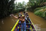 Wisatawan menikmati pemandangan alam saat wisata susur sungai di Banjarmasin, Kalimantan Selatan, Sabtu (27/6/2020). Pemprov Kalimantan Selatan terus berupaya meningkatkan kunjungan pariwisata, salah satunya wisata susur sungai di Banjarmasin yang menawarkan suasana alam serta aktivitas warga di bantaran sungai untuk menggaet para wisatawan baik dari dalam negeri maupun luar negeri. Foto Antaranews Kalsel/Bayu Pratama S.