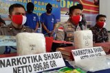 Kapolsek Entikong AKP Novrial Alberti Kombo (kedua kanan) didampingi Wakapolsek Entikong Iptu Muda Rezeki Pardosi (kiri) memaparkan kronologis penyelundupan sabu dari Malaysia di Mapolsek Entikong, Kabupaten Sanggau, Kalimantan Barat, Jumat (26/6/2020). Polsek Entikong menggagalkan penyelundupan empat paket sabu seberat 2,9 kilogram dari Malaysia yang dilakukan oleh dua tersangka kurir jaringan internasional berinisial RDM dan S melalui jalur tikus di kawasan perbatasan Entikong. ANTARA FOTO/Agus Alfian/jhw/pras.