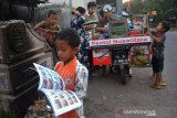 JUALAN PENTOL SAMBIL BAWA BUKU. Sejumlah bocah membaca buku yang dibawa Lutfan Efendi sambil berjualan pentol di Desa Ngudirejo, Kecamatan Diwek, Kabupaten Jombang, Jawa Timur, Sabtu (27/6/2020). Lutfan membawa buku bacaan mulai dari pengetahuan, buku cerita, dan beberapa yang lain ketika berjualan. Dengan membawa buku sambil berjualan ia berharap agar minat baca masyarakat terutama anak-anak semakin meningkat. Antara Jatim/Syaiful Arif/zk