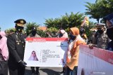 Kapolres Madiun Kota AKBP R. Bobby Aria Prakasa (kiri) menyerahkan secara simbolis Surat Izin Mengemudi (SIM) C kepada warga penerima saat Peluncuran Motor Tangguh Semeru dan Penyerahan SIM khusus dalam rangka HUT ke-74 Bhayangkara di halaman Polres Madiun Kota, Jawa Timur, Rabu (1/7/2020). Polres Madiun Kota meluncurkan Motor Tangguh Semeru yang akan digunakan untuk sosialisasi guna memberikan edukasi pencegahan penyebaran COVID-19 serta menyerahkan SIM C kepada 25 warga yang lahir pada 1 Juli bertepatan dengan Hari Bhayangkara. Antara Jatim/Siswowidodo/zk