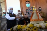 Gubernur Jawa Timur Khofifah Indar Parawansa (kedua kiri) memberikan potongan tumpeng kepada Kapolsek Genteng Kompol Anggi Saputra (kedua kanan) saat perayaan Hari Bhayangkara ke-74 tahun 2020 di Gedung Negara Grahadi, Surabaya, Jawa Timur, Rabu (1/7/2020). Gubernur Jawa Timur Khofifah Indar Parawansa merayakan Hari Bhayangkara ke-74 tahun untuk anggota kepolisian dengan melakukan pemotongan kue ulang tahun dan tumpeng. Antara Jatim/Didik/Zk