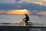 Seorang pengunjung melakukan olahraga bersepeda di pantai wisata Kampung Jawa, Banda Aceh, Jumat (3/7/2020). Olahraga bersepeda menjadi tren baru masyarakat dalam tatanan normal baru untuk meningkat stamina di tengah pandemi COVID-19. Antara Aceh/Ampelsa