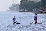 Dua orang wisatawan mancanegara berada di kawasan Pantai Seminyak yang masih ditutup dari kunjungan wisatawan di Badung, Bali, Jumat (3/7/2020). Pemerintah Kabupaten Badung berencana akan membuka kembali kawasan wisata pantai di wilayahnya pada 9 Juli mendatang dengan menerapkan protokol kesehatan secara ketat bagi seluruh pengunjung untuk mencegah penyebaran COVID-19. ANTARA FOTO/Fikri Yusuf/nym.