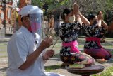 Pemuka agama Hindu menggunakan alat pelindung wajah saat memimpin persembahyangan di sela persiapan protokol kesehatan perayaan Hari Saraswati di Pura Agung Jagatnatha, Denpasar, Bali, Jumat (3/7/2020). Umat Hindu akan merayakan Hari Saraswati yaitu hari turunnya ilmu pengetahuan pada Sabtu (4/7/2020) dengan menerapkan protokol kesehatan COVID-19 termasuk mengatur jumlah umat Hindu saat memasuki area pura tersebut. ANTARA FOTO/Nyoman Hendra Wibowo/nym.