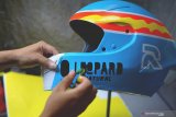 Seniman memodifikasi ulang desain warna dan sebagian bentuk helmet pabrikan dengan teknik 