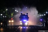 Polisi dengan kendaraan taktis 'Water Canon' menyemprotkan larutan disinfektan di  Jalan Tunjungan yang ditutup di Surabaya, Jawa Timur, Jumat (3/7/2020). Pihak kepolisian setempat kembali memberlakukan kawasan tertib 'physical distancing' atau jaga jarak secara fisik di tiga ruas jalan di Surabaya yaitu Jalan Tunjungan, Jalan Darmo dan Jalan Pandegiling mulai Jumat (3/7/2020) sampai Kamis (9/7/2020) pada jam 21.00 hingga 05.00 sebagai upaya untuk terus menekan penularan COVID-19. Antara Jatim/Didik/Zk