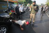 Petugas Satpol PP menghukum warga yang tidak mengenakan masker untuk 'push up' saat Operasi Patuh Masker di Jalan Nyamplungan, Surabaya, Jawa Timur, Senin (6/7/2020). Operasi yang digelar Pemkot Surabaya dan pihak kepolisian setempat itu guna mendisiplinkan warga untuk patuh terhadap protokol kesehatan pencegahan penularan COVID-19. ANTARA FOTO/Didik Suhartono/wsj.