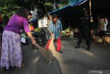 Petugas menghukum warga yang tidak memakai masker untuk menyapu jalan saat razia di Pasar Gersikan, Surabaya, Jawa Timur, Rabu (8/7/2020). Tindakan itu guna mendisiplinkan warga untuk patuh terhadap protokol kesehatan pencegahan penularan COVID-19. Antara Jatim/Didik/Zk