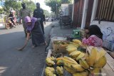 Petugas menghukum warga yang tidak memakai masker untuk menyapu jalan saat razia di Pasar Tuwowo, Surabaya, Jawa Timur, Rabu (8/7/2020). Tindakan itu guna mendisiplinkan warga untuk patuh terhadap protokol kesehatan pencegahan penularan COVID-19. Antara Jatim/Didik/Zk