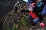 Masyarakat Suku Tengger  melarung uang ke kawah Gunung Bromo dalam rangka perayaan Yadnya Kasada, Probolinggo, Jawa Timur, Selasa (7/7/2020). Perayaan Yadnya Kasada merupakan bentuk ungkapan syukur dan penghormatan kepada leluhur masyarakat Suku Tengger dengan cara melarung sesaji berupa hasil bumi dan ternak ke kawah Gunung Bromo. Antara Jatim/Zabur Karuru