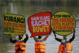 Aktivis lingkungan hidup dari Ecological Observation and Wetlands Conservation (Ecoton) membentangkan poster tulisan saat melakukan aksi darurat pencemaran mikroplastik di sungai kawasan Keputran, Surabaya, Jawa Timur, Kamis (9/7/2020). Aksi tersebut sebagai bentuk keprihatinan atas temuan tim peneliti Ecoton yang menemukan sejumlah polutan berbahaya dan mengidentifikasi enam mikroplastik dari bentukan fiber, fragment, filament, granular, foam dan pelet yang dapat merusak ekosistem serta mencemari sungai di Surabaya. Antara Jatim/Moch Asim/zk.