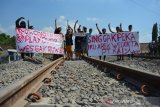 Warga menggelar aksi unjuk rasa menolak pembangunan flyover atau jalan layang untuk pejalan kaki di pelintasan sebidang jalur ganda KA yang melintasi Dusun Karangnongko, Desa Mojoranu, Kecamatan Sooko, Kabupaten Mojokerto, Rabu (8/7/2020). Mereka menuntut PT KAI membangun underpass yang bisa dilalui kendaraan bukan jalan layang untuk pejalan kaki, sehingga memudahkan warga beraktivitas saat hendak menuju ke dusun seberang rel di Desa setempat. Antara Jatim/Syaiful Arif/zk