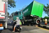 Pengendara melintas di samping truk kontainer yang mengalami kecelakaan tunggal di jalur pantura Karanganyar, Demak, Jawa Tengah, Rabu (8/7/2020). Kecelakaan truk kontainer yang menabrak pembatas jalan yang diduga akibat tidak berfungsinya rem itu menghalangi pemakai jalan lainnya dan riskan menyebabkan kecelakaan jika tidak segera dipindahkan ke lokasi aman. ANTARA FOTO/Yusuf Nugroho/aww.