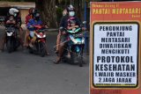 Pengunjung memasuki kawasan pantai pada hari pertama penerapan normal baru tahap I di Pantai Mertasari, Denpasar, Bali, Kamis (9/7/2020). Meskipun obyek wisata mulai dibuka untuk warga lokal tapi Pemerintah Kota Denpasar tetap membatasi pengunjung untuk menjaga jarak fisik sehingga dapat menghindari penyebaran COVID-19. ANTARA FOTO/Nyoman Hendra/Wibowo/nym.