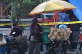 Pedagang berada di luar pasar Pahing yang ditutup di Kota Kediri, Jawa Timur, Jumat (10/7/2020). Pemerintah daerah setempat menutup pasar tradisional itu selama tiga hari pasca seorang pedagang dinyatakan positif COVID-19. Antara Jatim/Prasetia Fauzani/zk