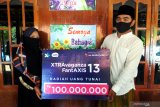 Pemenang uang tunai Rp100 juta Program Xtravaganza dan FantAXIS Zahratul Gamelia (kiri) bersama suami menunjukkan hadiah di Desa Kamondung, Sampang, Jawa Timur, Jumat (10/7/2020). Zahratul Gamelia menjadi pemenang hadiah Rp100 juta Program Xtravaganza dan FantAXIS yang merupakan program apresiasi atas loyalitas pelanggan XL Axiata, baik yang menggunakan nomor prabayar XL dan AXIS, maupun pascabayar XL Prioritas. Antara Jatim/Saiful Bahri/zk