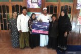 Pemenang hadiah Rp100 juta Program Xtravaganza dan FantAXIS  Zahratul Gamelia (ke tiga kiri) saat penyerahan hadiah berpose bersama keluarga di Desa Kamondung, Sampang, Jawa Timur, Jumat (10/7/2020). Program Xtravaganza dan FantAXIS merupakan program apresiasi atas loyalitas pelanggan XL Axiata, baik yang menggunakan nomor prabayar XL dan AXIS, maupun pascabayar XL Prioritas. Antara Jatim/Saiful Bahri/zk