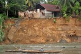 Sebuah rumah nyaris roboh di tebing sungai di Salisikan, Nagari Sungai Buluh Timur, Batang Anai, Padangpariaman, Sumatera Barat, Kamis (9/7/2020). Sedikitnya tiga rumah di bantaran sungai Batang Anai tersebut terancam roboh karena dinding tebing tergerus aliran sungai dan sebagian warga melakukan evakuasi mandiri. ANTARA FOTO/Iggoy el Fitra/aww.