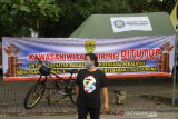 Seorang warga melintas di dekat spanduk penutupan kawasan wisata Siring Sungai Martapura di Jalan Kapten Piere Tandean Banjarmasin, Kalimantan Selatan, Minggu (12/7/2020). Pemerintah Kota Banjarmasjn menutup kembali wisata Siring Sungai Martapura di Jalan Kapten Piere Tandean dengan alasan menghindari terjadinya kerumunan warga untuk mencegah penyebaran COVID-19. Foto Antaranews Kalsel/Bayu Pratama S.