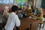 Guru menyiapkan materi saat Masa Pengenalan Lingkungan Sekolah (MPLS) di SDN Lawangan Daya 2, Pamekasan, Jawa Timur, Senin (13/7/2020). Pelaksanaan MPLS bagi siswa baru dan Kegiatan Belajar Mengajar (KBM) dimasa Pandemi COVID-19 dilakukan secara daring dan luring . Antara Jatim/Saiful Bahri/zk