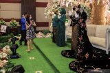 Tamu undangan memberikan ucapan selamat kepada pasangan pengantin Fahreza Ahmad dan Mafella Firdausi beserta keluarganya dengan menjaga jarak fisik saat simulasi resepsi pernikahan di masa normal baru di Fave Hotel Sidoarjo, Jawa Timur, Senin (13/7/2020). Kegiatan simulasi resepsi pernikahan tersebut bertujuan untuk mengedukasi masyarakat tentang pentingnya penerapan protokol kesehatan dalam acara pernikahan guna mencegah penyebaran dan penularan COVID-19 di masa normal baru. Antara Jatim/Umarul Faruq/zk